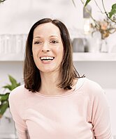 Portrait von lachende Frau mit braunen Haaren bis zu den Schultern.